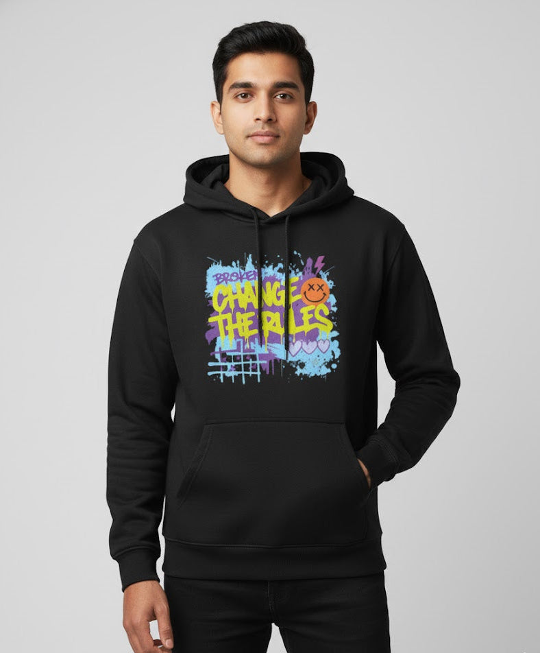Man wearing a black hoodie with colorful text and graphics on a gray background