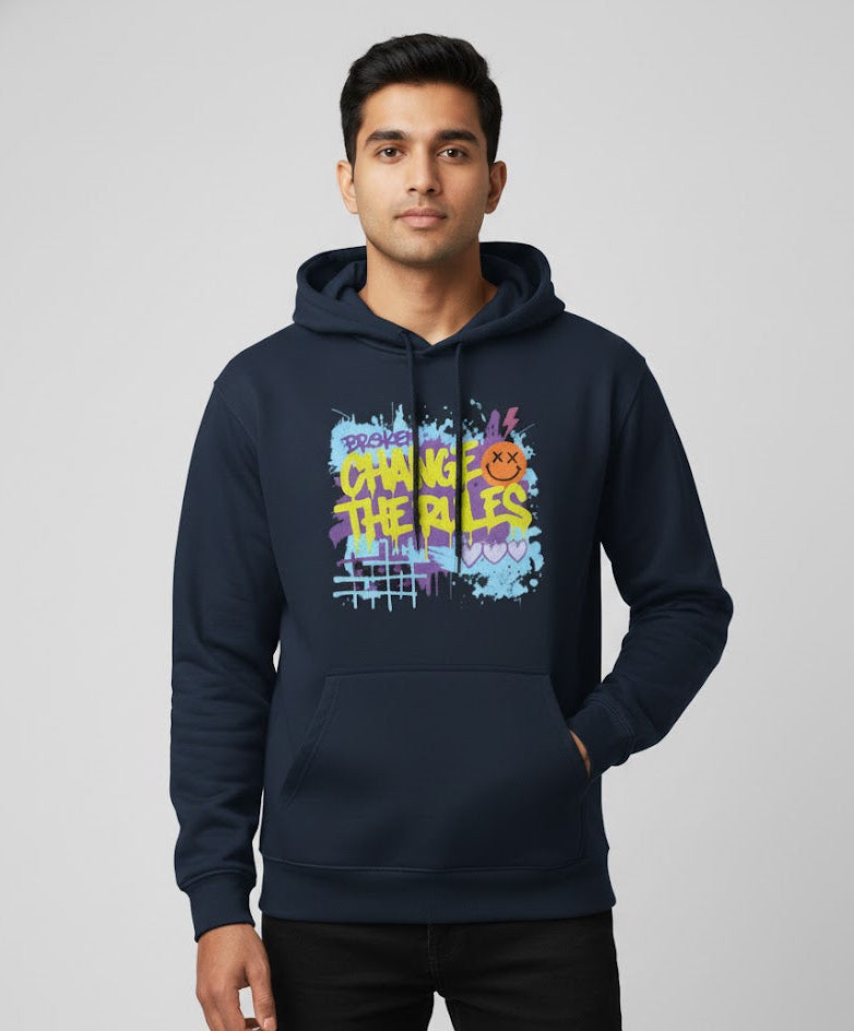 Man wearing a navy blue hoodie with colorful text and graphics on a gray background