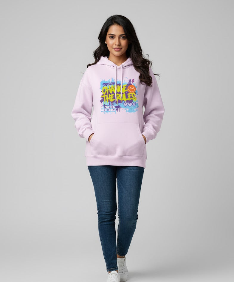 Woman wearing a pink hoodie with colorful graphics on a gray background